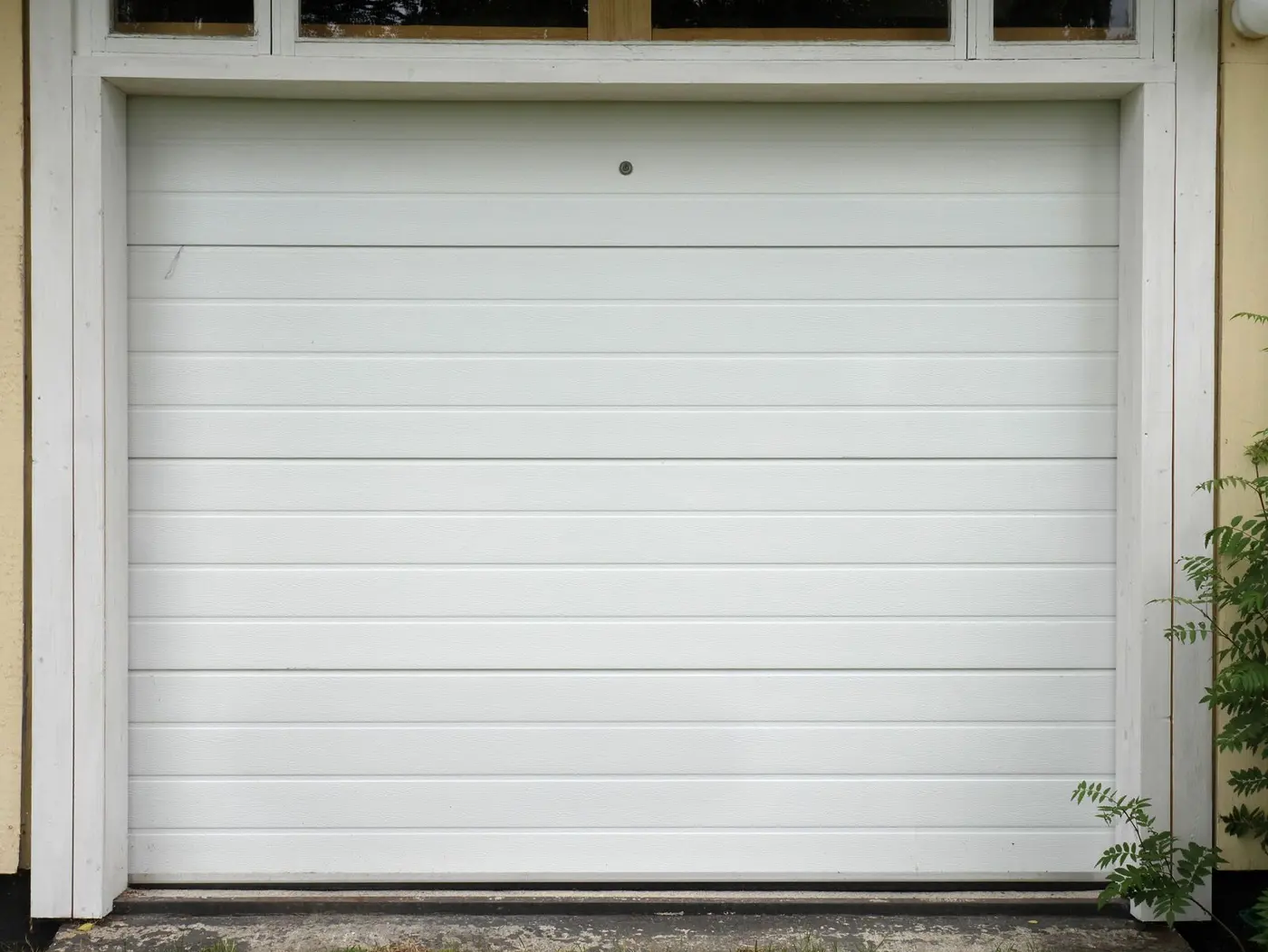 A white sectional garage door, closed